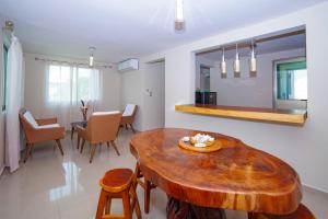 a living room with a wooden table and chairs at Newly renovated apartment with pool in Santa Cruz Huatulco