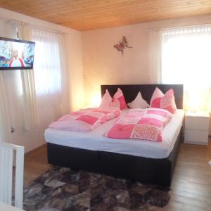 a bedroom with a bed with pink and white pillows at Lehnhäusl Aschauer in Berchtesgaden