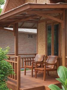 a pergola with chairs and a table on a deck at Ocean Fresh Surfhouse in Pulau Sarang