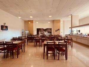 a restaurant with wooden tables and chairs and a buffet at Hotel Binder Quality Inn in Mogi das Cruzes