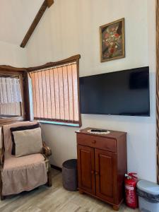 a living room with a large flat screen tv and a chair at Apartmani Mladenovac in Mladenovac