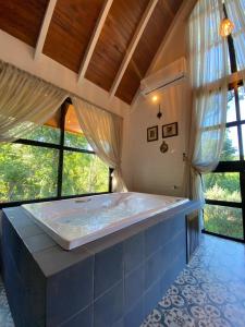 a large bath tub in a room with windows at Cabana Vale das Bromélias in Videira +27 photos
