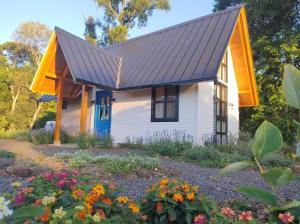 a small white house with a metal roof at Cabana Vale das Bromélias in Videira