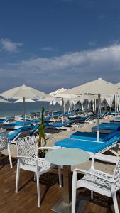 a group of chairs and tables and umbrellas on a beach at Blue Heaven Seaside in Borsh