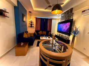 a living room with a couch and a tv at Dreamland royal suite in Rawalpindi