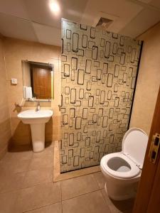 a bathroom with a white toilet and a sink at Dreamland royal suite in Rawalpindi +7 photos