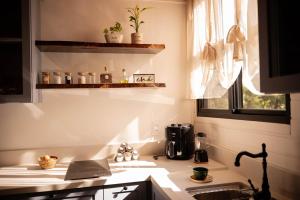 a kitchen with a sink and a stove and a window at Cabana Vale das Bromélias in Videira