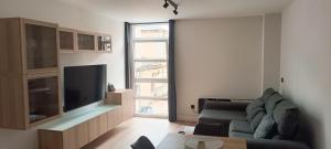 a living room with a couch and a flat screen tv at Manisa I in Ribadeo