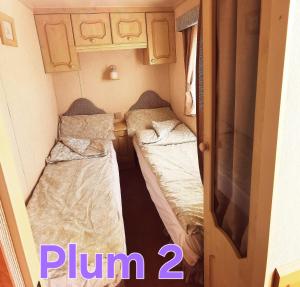 a small room with two beds in a caravan at Plum 2, luxury 3 bed 8 berth, gas central heating, bedding included, Static caravan with large wrap around secure veranda on Coral Beach in Ingoldmells in Ingoldmells