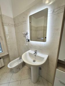 a white bathroom with a sink and a mirror at Torre Sole Fiumara in Genoa +28 photos