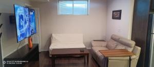 a living room with a couch and a flat screen tv at Parson Creek Retreat in Fort McMurray