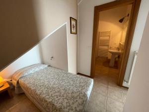 a small bedroom with a bed and a hallway at Residence The Cherry House - Appartamenti con piscina in Carro