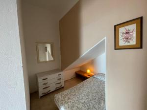 a bedroom with a bed and a dresser and a staircase at Residence The Cherry House - Appartamenti con piscina in Carro +119 photos
