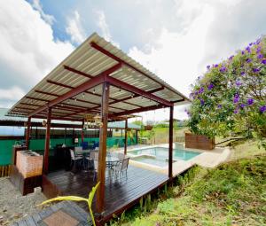 a pavilion with a table and chairs next to a pool at Paulos View Lodge in Colonia
