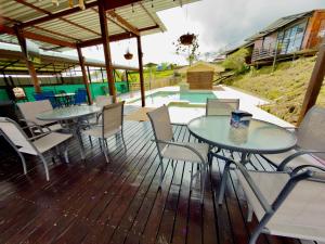 two tables and chairs on a deck with a pool at Paulos View Lodge in Colonia