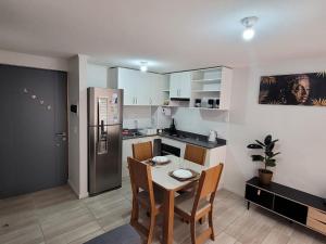 a small kitchen with a table and a refrigerator at Depto Comodo y full equipado in Antofagasta +26 photos