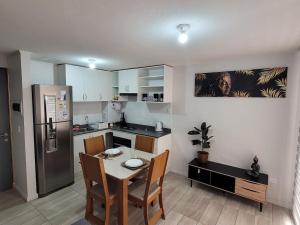 a kitchen with a table and chairs and a refrigerator at Depto Comodo y full equipado in Antofagasta