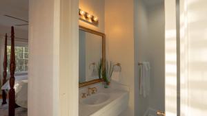 a bathroom with a sink and a mirror and a tub at Thurston House Inn in Ocracoke +24 photos