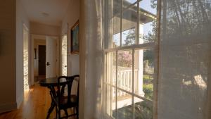 a room with a table and a large window at Thurston House Inn in Ocracoke