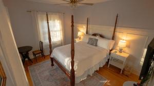a bedroom with a canopy bed and a window at Thurston House Inn in Ocracoke