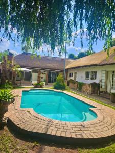 a swimming pool in front of a house at Midrand Manor Guesthouse in Midrand