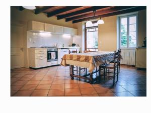 a kitchen with a table and a kitchen with white appliances at maison bourgeoise in Rouffignac