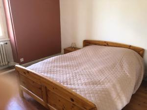 a bedroom with a bed with a wooden frame at Chez Cathy in Saint-Donat-sur-lʼHerbasse
