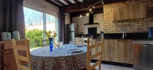 a table with a blue vase on it in a kitchen at Retour en Baie in Pendé