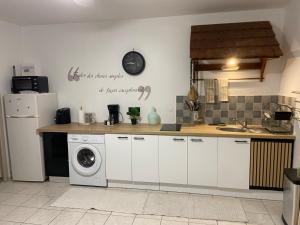 eine Küche mit Waschmaschine und Spüle in der Unterkunft Appartement l'Ecrin 2 in Saint-Claude