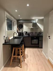 a kitchen with a black counter top and a sink at Det Lille huset på Storgata - Leilighet in Larvik