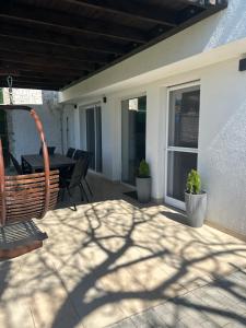 a patio with a table and chairs on a house at Sun&Fun Vendégház in Balatonakarattya +70 photos