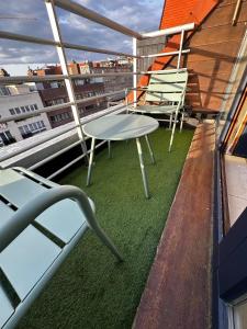two chairs and a table on a balcony at Léonardo in Nieuwpoort