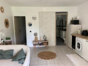 ein Wohnzimmer mit Sofa und eine Küche in der Unterkunft Appartement l'Ecrin 2 in Saint-Claude