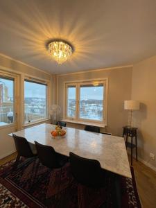 a dining room with a table with chairs and windows at Sunshine apartment in Stockholm