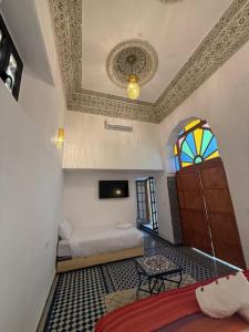 a bedroom with a bed and a window and a ceiling at Riad Mira in Fez