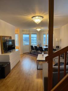 a living room with a television and a dining room at Sunshine apartment in Stockholm