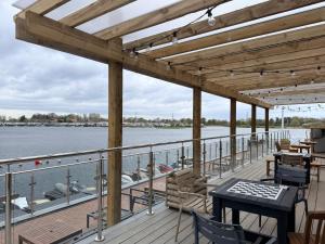 a deck with tables and chairs on the water at Riverside Haven in Crowle