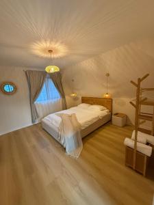 a bedroom with a bed and a wooden floor at Alpin Chalet & SPA in Mănăstirea Humorului
