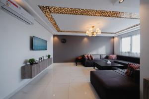 a living room with a couch and a tv at Résidences Nador in Nador