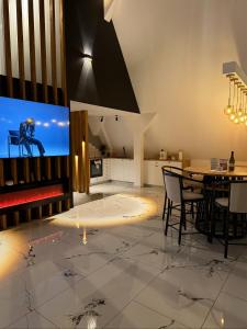a dining room with a table and a tv at Alpin Chalet & SPA in Mănăstirea Humorului