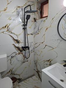 a bathroom with a marble wall at Cabana Lir in Arad