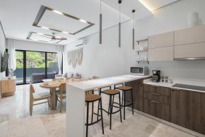 a kitchen with a counter and a table with stools at Private Pool with Beach Access and Baby Crib - Tulum Hotel Zone in Tulum
