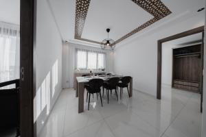 a dining room with a table and black chairs at Résidences Nador in Nador +12 photos