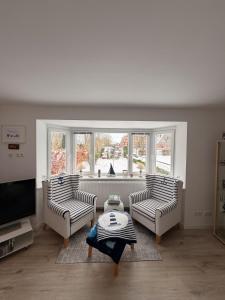 a living room with two chairs and a large window at Wohlfühlbude Fehmarn in Fehmarn