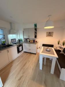 a kitchen with a table in the middle of a room at Wohlfühlbude Fehmarn in Fehmarn