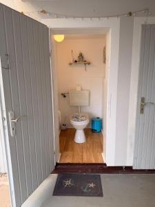a small bathroom with a toilet in a room at Wohlfühlbude Fehmarn in Fehmarn +14 photos