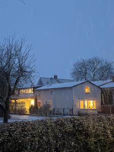 a large white barn in the snow at night at Wohlfühlbude Fehmarn in Fehmarn