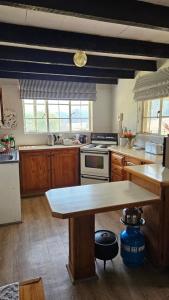 a kitchen with wooden cabinets and a table in it at Kamberg Cottages in Mooiriver +23 photos