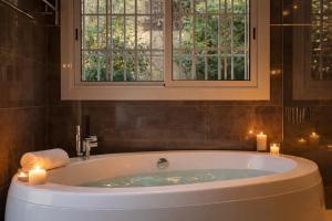 a bath tub with two candles in a bathroom at Cabril's Hills - Stunning Villa with Pool & Sea Views in Cabrils