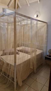 a bed covered in mosquito nets in a room at Ô Logis Zen' in Le Moule +38 photos